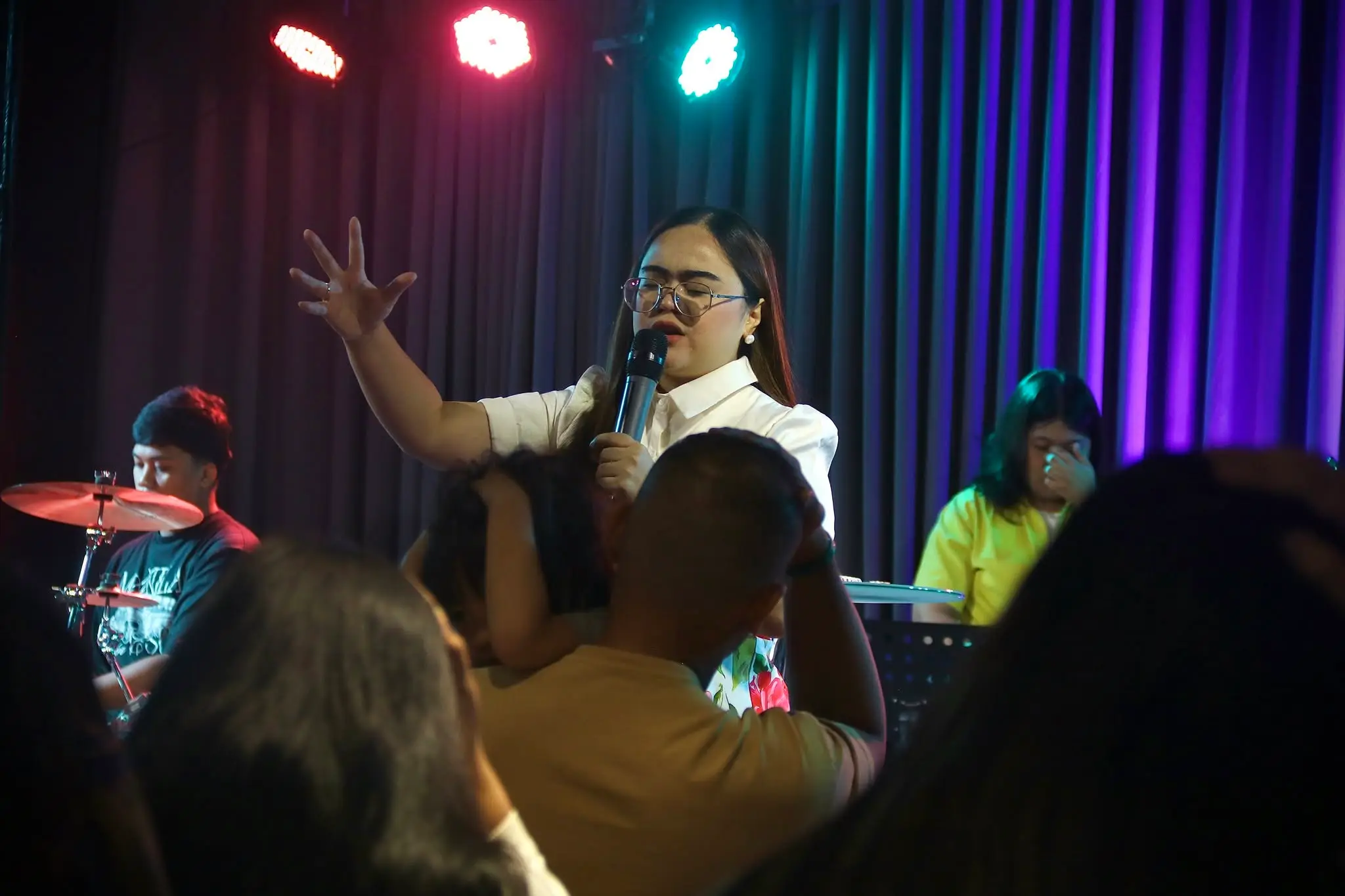 A worship leader singing with the congregation during Sunday service
