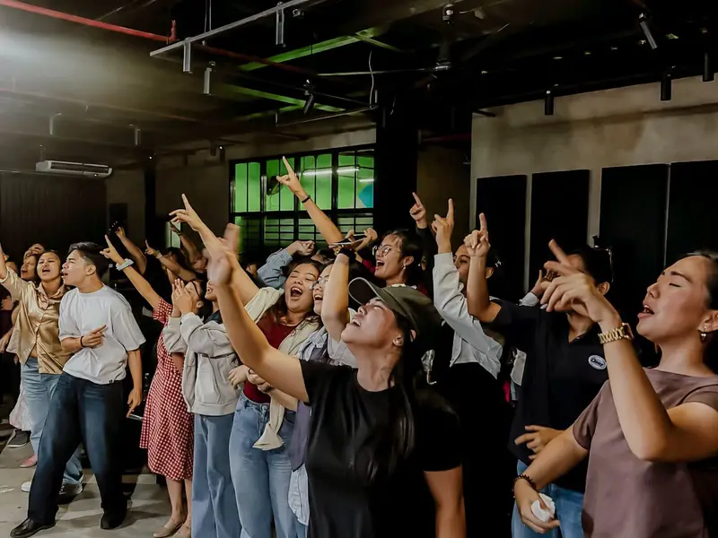 A crowd worshipping with hands raised