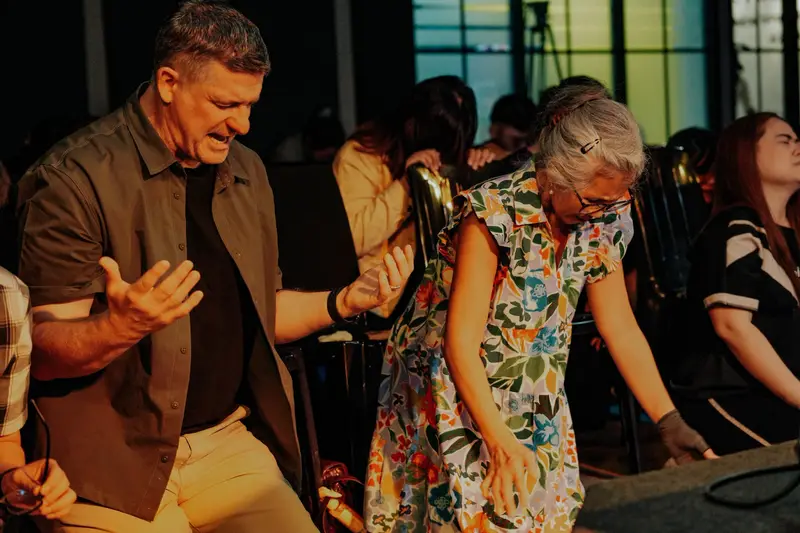 A pastor praying over a woman at the altar