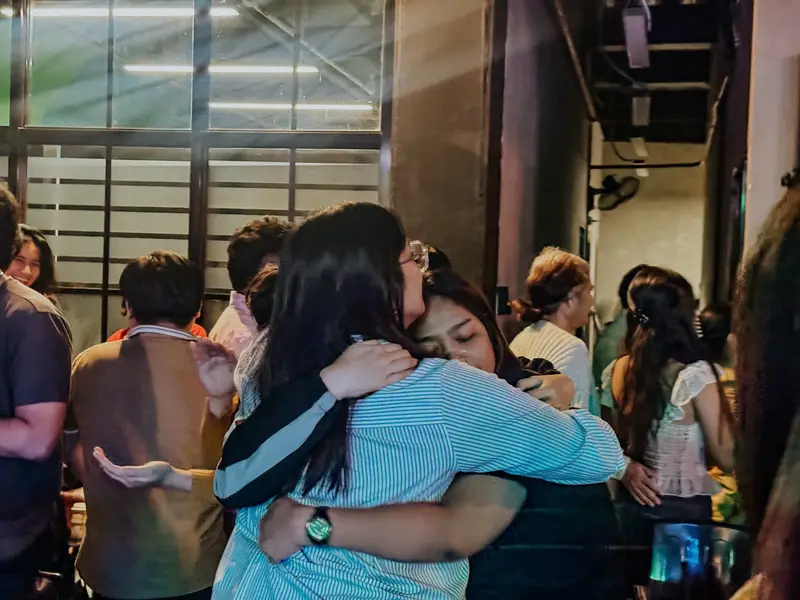 Two friends sharing a warm hug after service