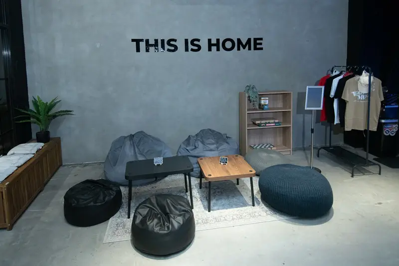 A cosy lounge with bean bags under a “This Is Home” sign